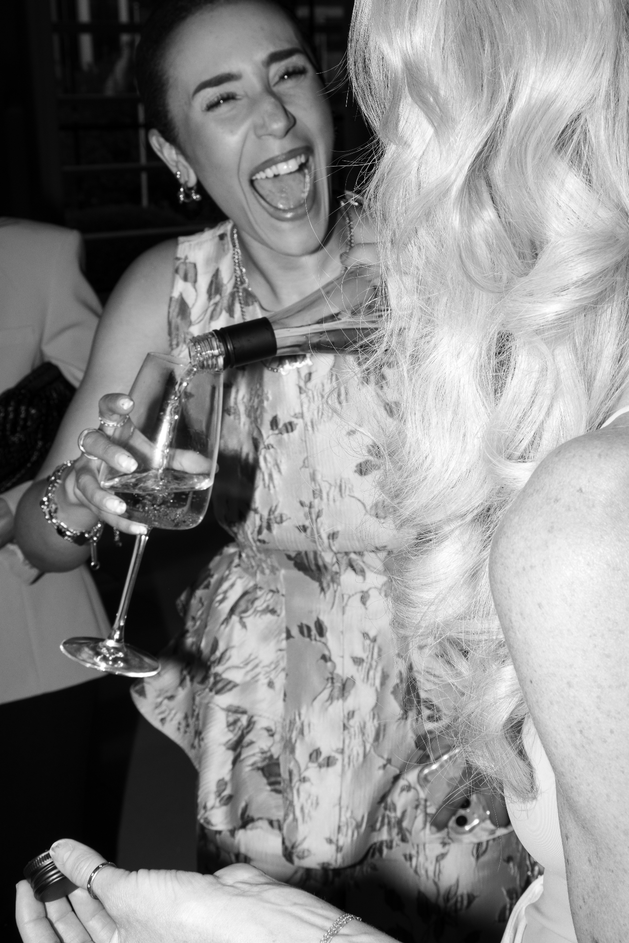 Friends laughing as rosé is poured into a glass